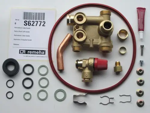 Remeha Hydroblock mit verschiedenen Verbindungselementen, Dichtungen und Zubehörteilen. Sichtbare Komponenten: ein Hauptblock, Rohre, Unterlegscheiben und Sicherheitsclips.